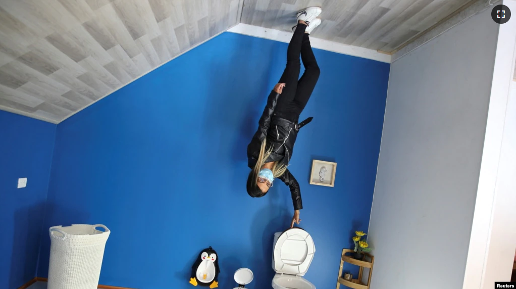 FILE - A woman poses for a photo inside the upside down house in Guatavita, Colombia, January 23, 2022. (Reuters Photo/Luisa Gonzalez)