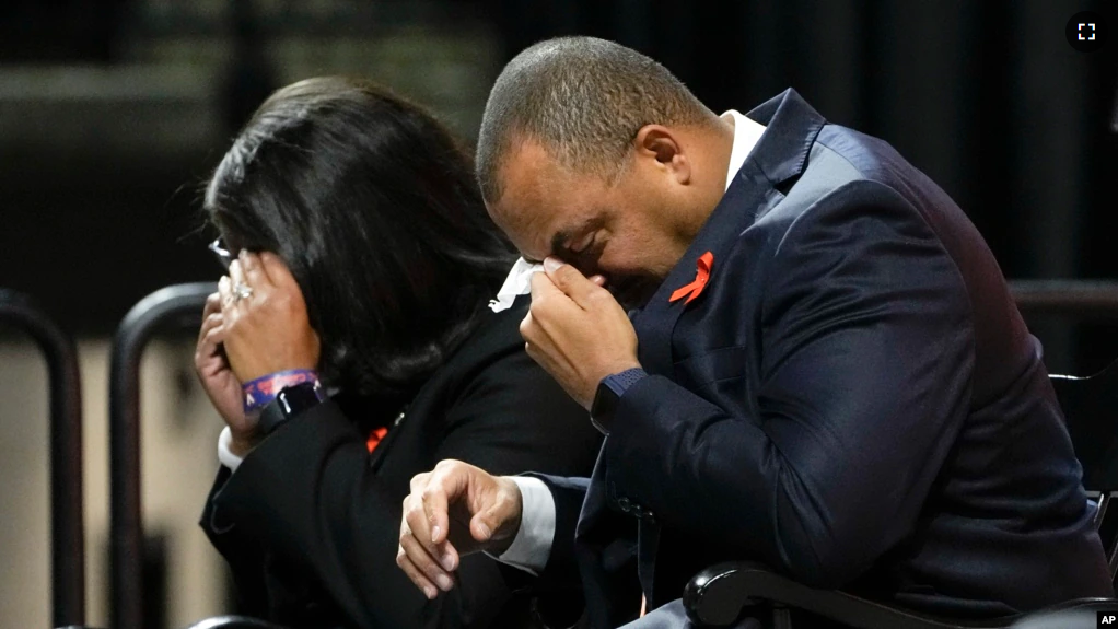 University of Virginia Athletic Director Carla Williams, left, and football coach Tony Elliott wipe tears from their eyes during a memorial service for three slain University of Virginia football players in Charlottesville, Va., Nov. 19, 2022. (AP Photo/Steve Helber, Pool)