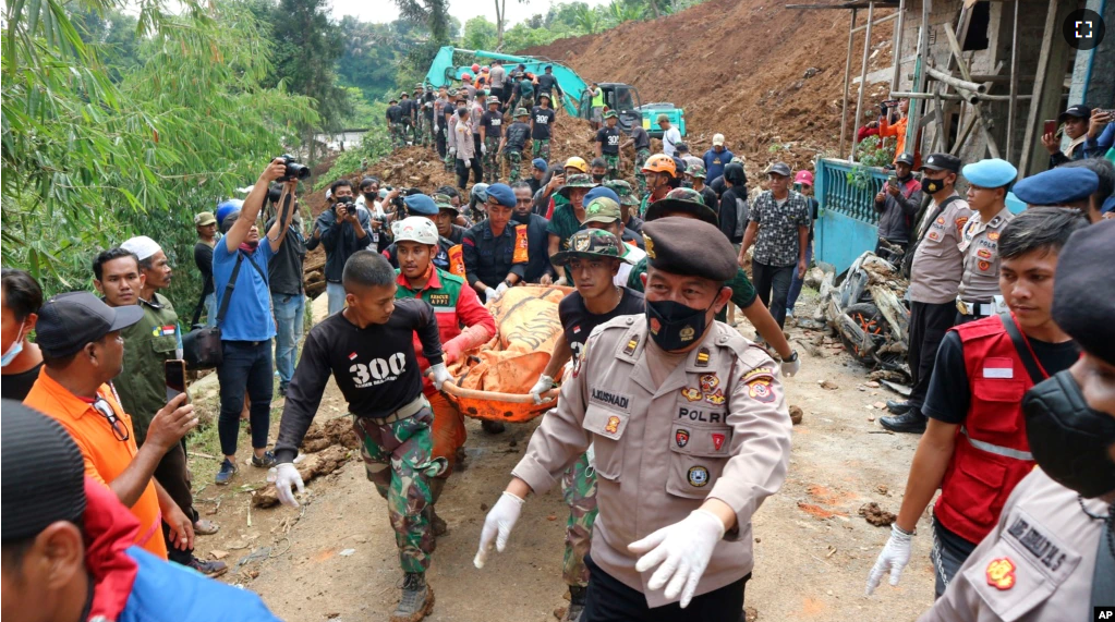 Rescuers carry the body of a victim recovered from under the rubble at a village affected by an earthquake-triggered landslide in Cianjur, West Java, Indonesia, Tuesday, Nov. 22, 2022. (AP Photo/Rangga Firmansyah)