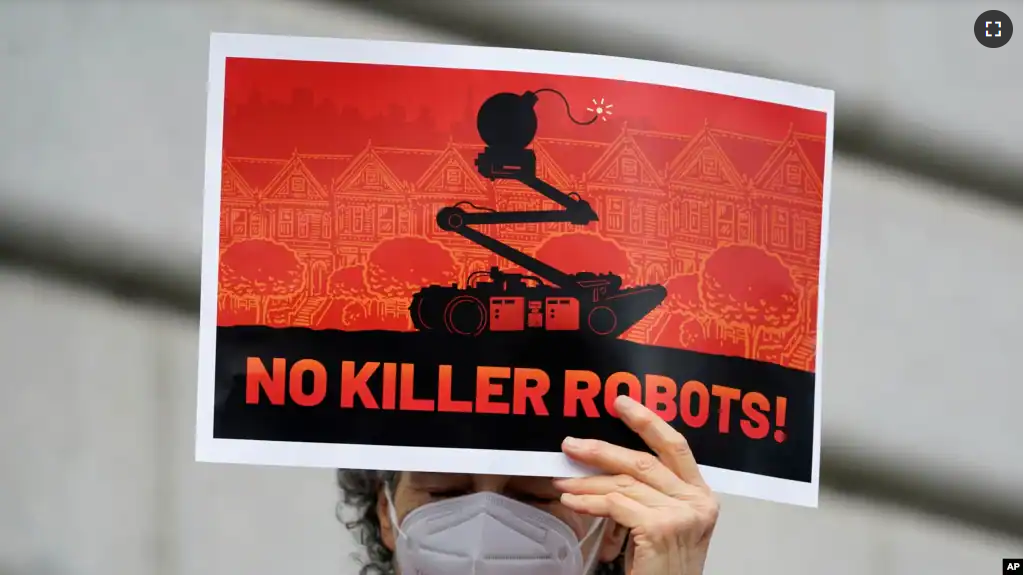 A woman holds up a sign while taking part in a demonstration about the use of robots by the San Francisco Police Department outside of City Hall in San Francisco, Monday, Dec. 5, 2022. (AP Photo/Jeff Chiu)