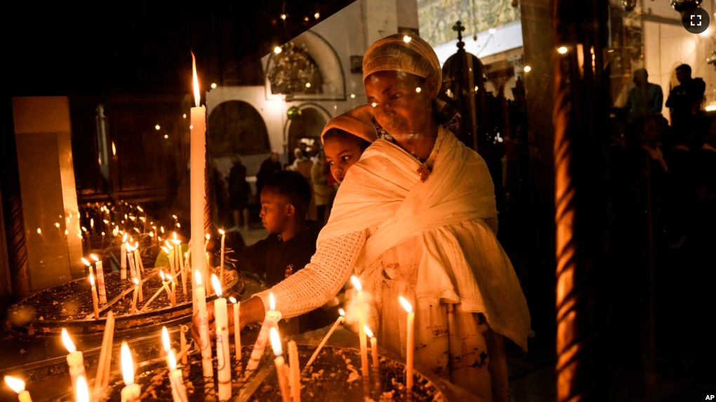 An Ethiopian woman and her child visit the Church of the Nativity, traditionally believed to be the birthplace of Jesus Christ, in the West Bank town of Bethlehem, Saturday, Dec. 3, 2022. Business in Bethlehem is returning after the pandemic. (AP Photo/ Mahmoud Illean)