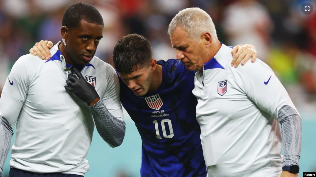 Christian Pulisic of the U.S. receives medical attention after colliding with Iran's Alireza Beiranvand after scoring the first goal on November 29, 2022. (REUTERS/Kai Pfaffenbach)