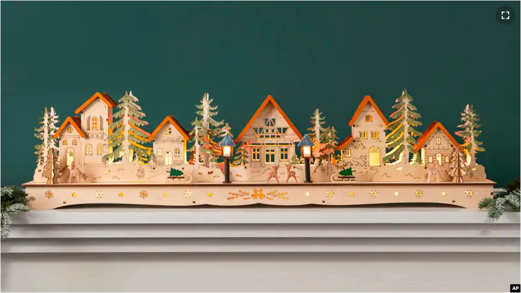 This image provided by Balsam Hill shows their Christmas Mantel Village. The village is crafted of plywood and hand painted. With built-in lights, it's a charming Victorian-era decoration for mantels, windows or tabletops. (Balsam Hill via AP)