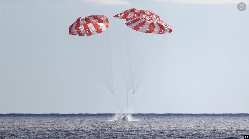 NASA's Orion capsule splashes down Sunday, Dec. 11, 2022, to conclude a dramatic 25-day test flight, as seen from aboard the U.S.S. Portland in the Pacific off Mexico. (Mario Tama/Pool Photo via AP)