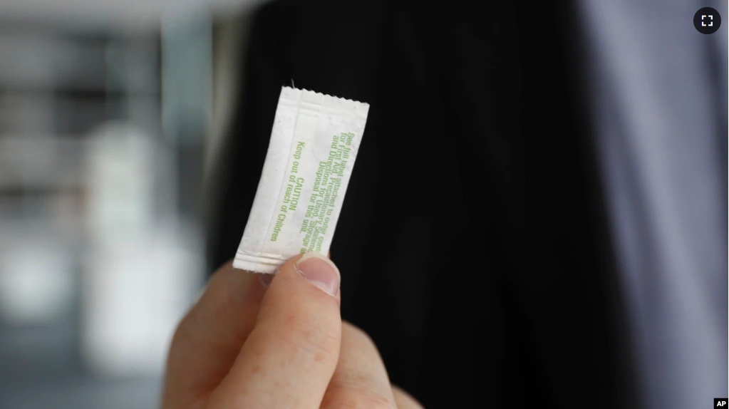 In this photo taken Monday, Oct. 24, 2022, in Chicago, Patrick Flynn, a co-founder of Hazel Technologies, holds a sachet designed to slow the ripening of process of various fruits. (AP Photo/Martha Irvine)