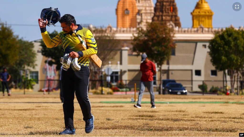 Pavan Kumar Machiraju walks off the field after batting during a cricket match between the Dallas Cricket Connections and the Kingswood Cricket Club, as the Karya Siddhi Hanuman Temple is seen in the background, in Frisco, Texas, Oct. 22, 2022. (AP Photo/Andy Jacobsohn)