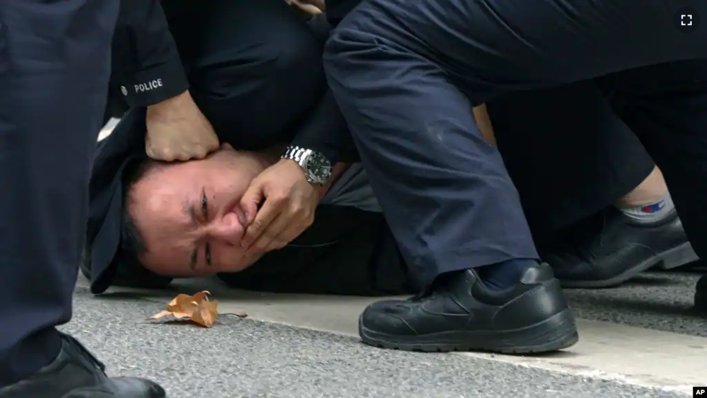 FILE - Policemen pin down and detain a protester during a protest on a street in Shanghai, China on Nov. 27, 2022. (AP Photo, File)