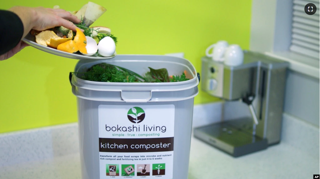 This image provided by Bokashi Living shows kitchen scraps being added to a bokashi composting bucket. (bokashiliving.com via AP)