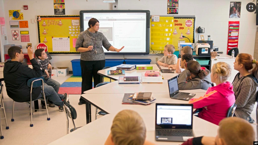 FILE - In this photo taken Feb. 12, 2015, sixth grade teacher Carrie Young guides her students through an exercise on their laptops. (AP Photo/Ty Wright)