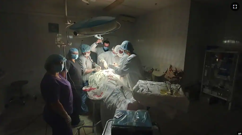 This photo made available by Ukrainian doctor Oleh Duda shows the moment when lights at a hospital went out as he was performing complicated, dangerous surgery. (Oleh Duda via AP)