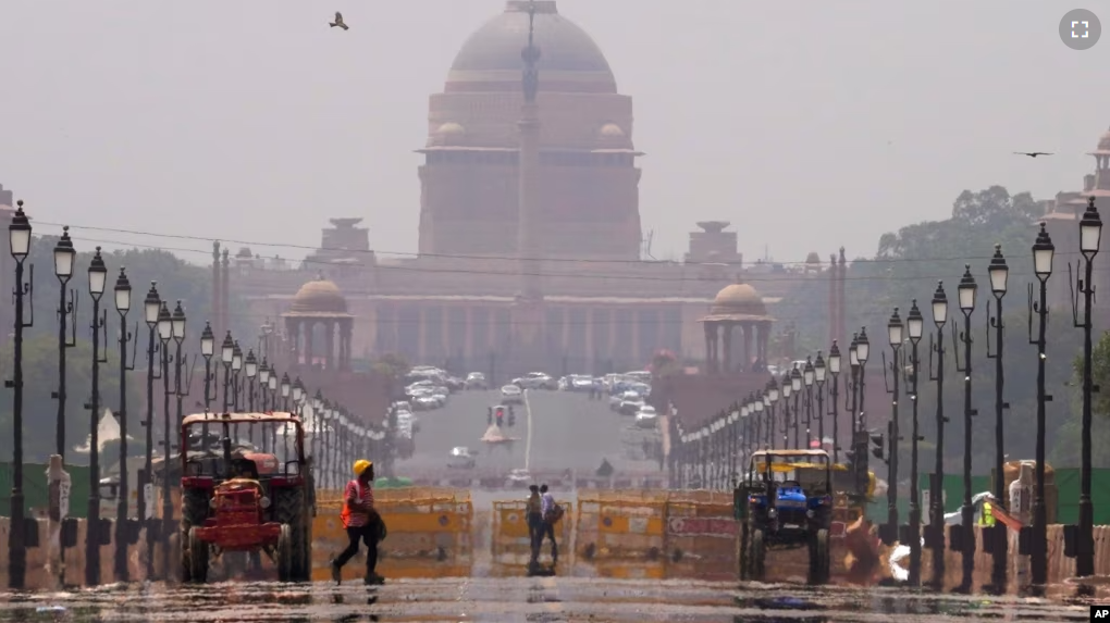 FILE - A construction worker walks across a road during a heat wave, in New Delhi, May 2, 2022. (AP Photo/Manish Swarup)