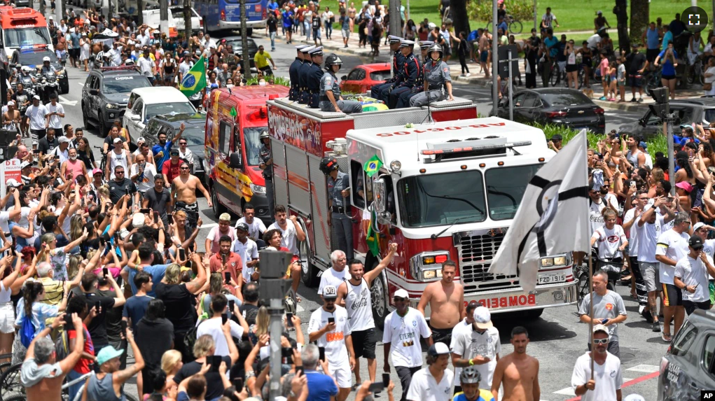 A fire truck brings the casket containing the body of Pele to the cemetery after his funeral in Santos, Brazil on Tuesday. (AP Photo/Matias Delacroix)