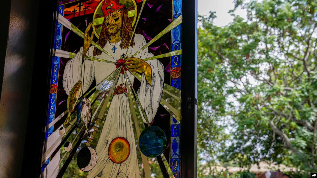 A stained glass windows depicting a Stations of the Cross scene created by French-born artist Delphine Poulain, hangs in the Holy Cross church, in Hanga Roa, Rapa Nui or Easter Island, Monday, Nov. 28, 2022. (AP Photo/Esteban Felix)