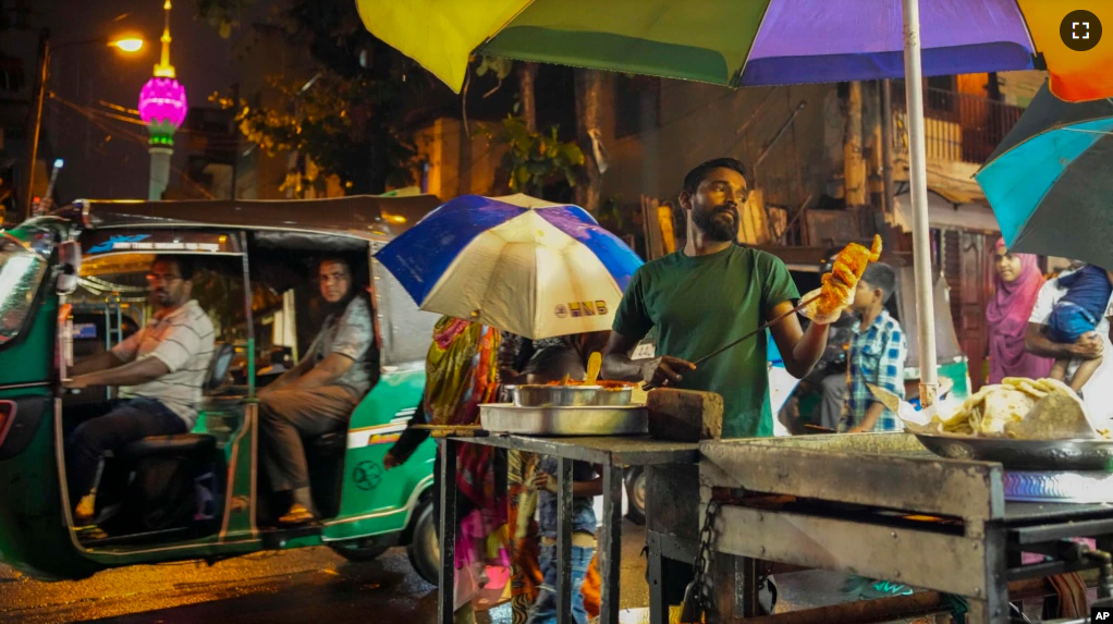 A street vendor prepares food in Colombo, Sri Lanka, Wednesday, Dec. 28, 2022. (AP Photo/Eranga Jayawardena)