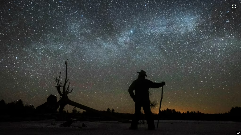 In this file photo, Dave Cooke observes the Milky Way over a frozen fish sanctuary in central Ontario, north of Highway 36 in Kawartha Lakes, Ontario, Canada, early Sunday, March 21, 2021. (Fred Thornhill/The Canadian Press via AP)