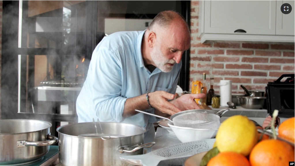 This image provided by Discovery shows host Jose Andres in the kitchen cooking for his family and friends in Asturias in a scene from the Discovery + television series "Jose Andres and Family in Spain." (Discovery via AP)