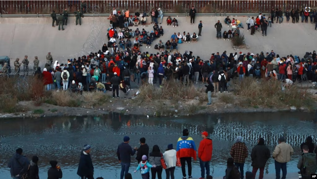 FILE - Migrants gather at a crossing into El Paso, Texas, as seen from Ciudad Juarez, Mexico, Dec. 20, 2022. (AP Photo/Christian Chavez, File)