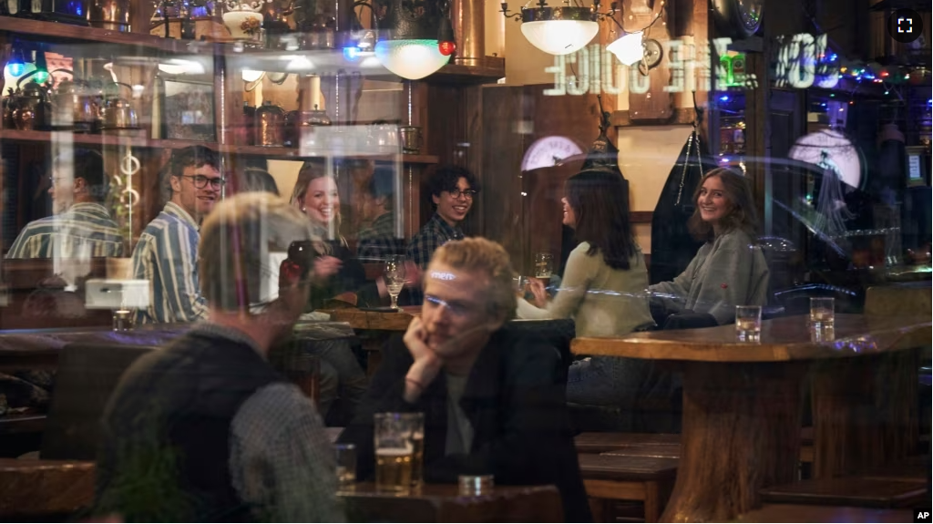 FILE - People sit in a bar in Stockholm, Sweden, on March 25, 2020. Sweden wants to cut red tape when it comes to dancing. (AP Photo/David Keyton, File)