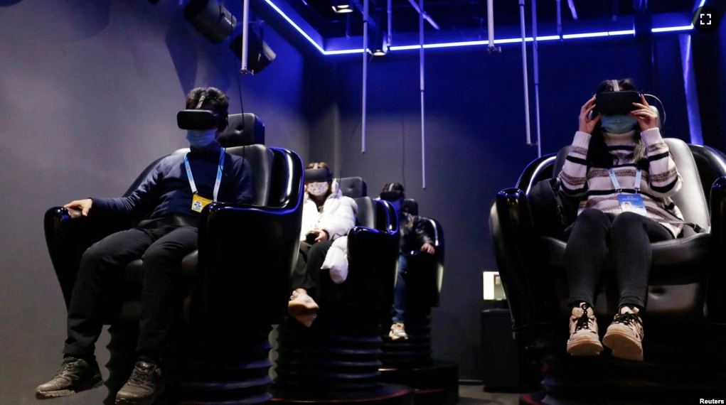 People try virtual reality (VR) goggles during an organised media tour to a demonstration zone of Leyard Photoelectric Group in Beijing, China February 10, 2022. (REUTERS/Florence Lo)