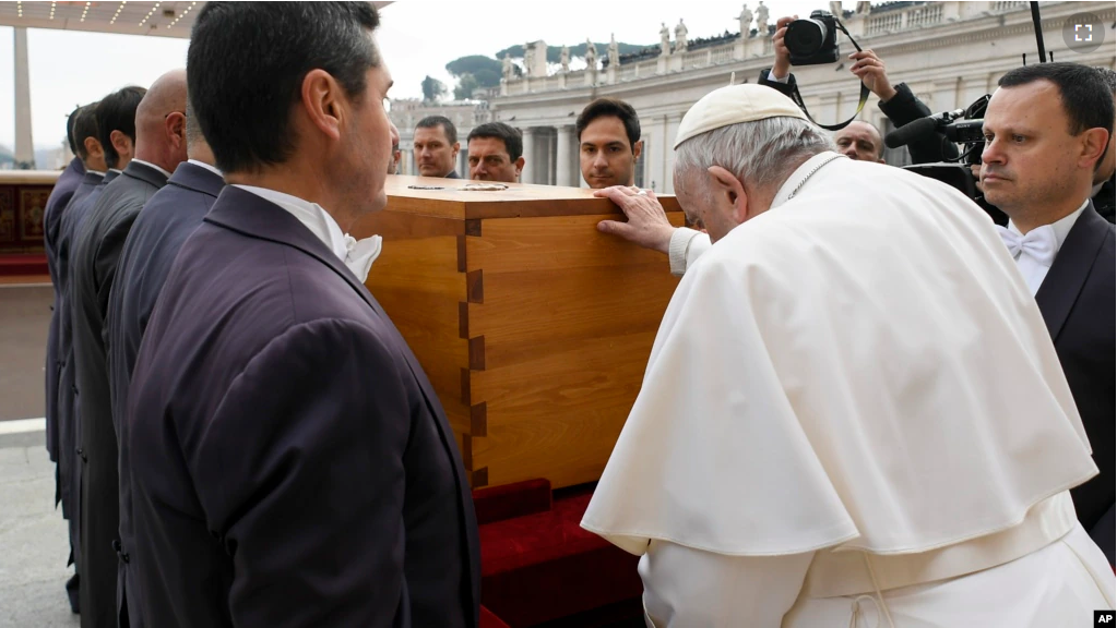 In this image released by the Vatican Media news service, Pope Francis touches the coffin of late Pope Emeritus Benedict XVI after his funeral mass in St. Peter's Square at the Vatican, Jan. 5, 2023.