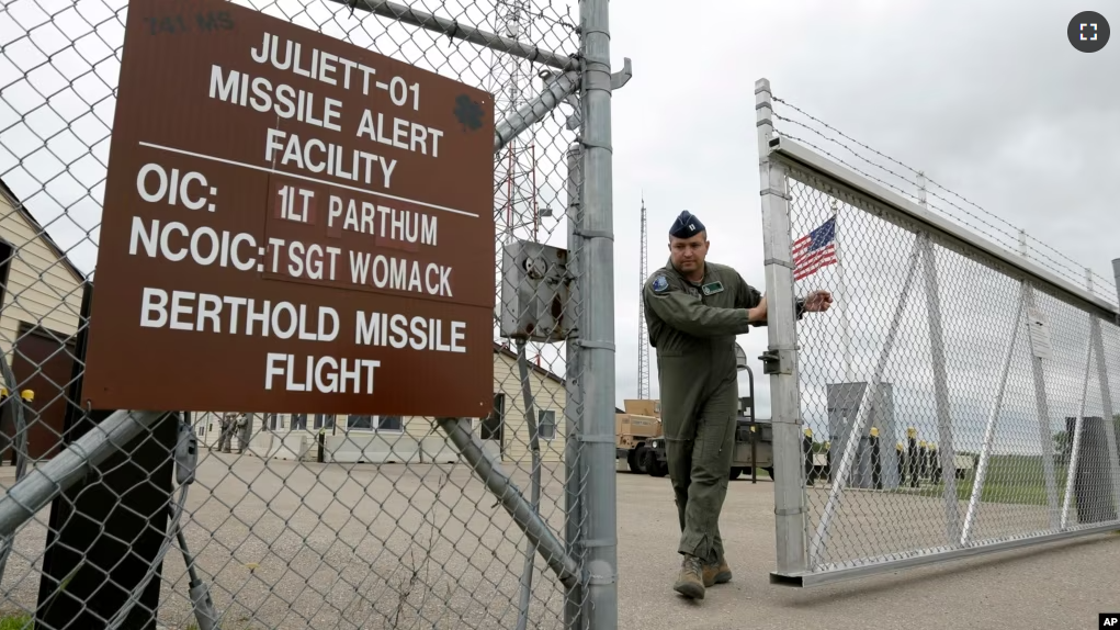 FILE - This photo taken June 24, 2014 shows Capt. Robby Modad closing the gate at an ICBM launch control facility in the countryside outside Minot, N.D., on the Minot Air Force Base. (AP Photo/Charlie Riedel)