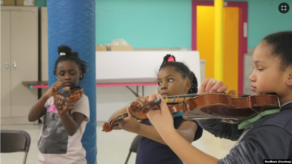 Students practice string instruments with RocMusic in this undated file photo. (Photo courtesy of RocMusic)