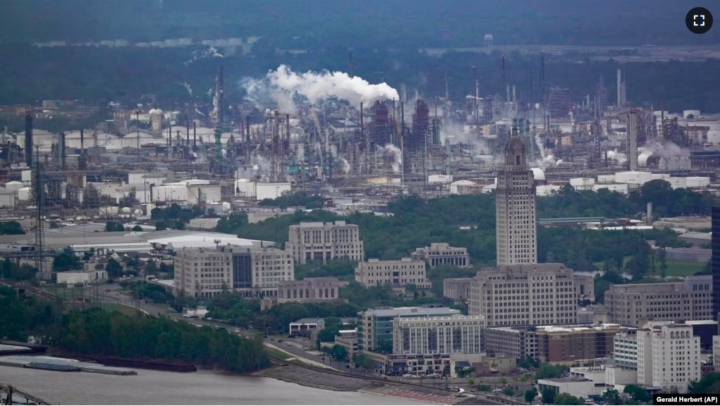 FILE - The Exxon Mobil Baton Rouge Refinery complex with the Louisiana State Capitol, bottom right, in Baton Rouge, La., Monday, April 11, 2022. (AP Photo/Gerald Herbert)