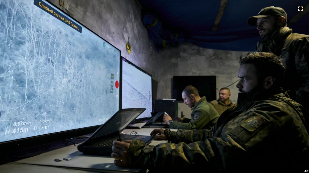 Ukrainian soldiers watch drone feeds from an underground command center in Bakhmut, Donetsk region, Ukraine, Sunday, Dec. 25, 2022. (AP Photo/Libkos)