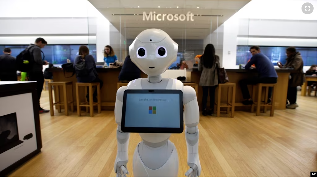 In this Sunday, March 21, 2019 photo a robot called "Pepper" is positioned near an entrance to a Microsoft Store location, in Boston. (AP Photo/Steven Senne)