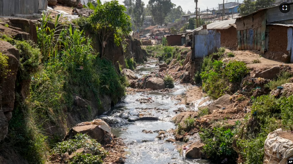 A tributary full of garbage, which feeds into the Nairobi River, flows through the informal settlement of Kibera in Nairobi, Kenya, Wednesday, Jan. 11, 2023. (AP Photo/Khalil Senosi)