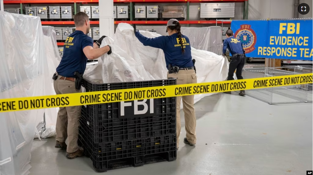 In this image provided by the FBI, FBI special agents assigned to the evidence response team process material recovered from the high altitude balloon recovered off the coast of South Carolina, Thursday, Feb. 9, 2023, at the FBI laboratory in Quantico, Va., (FBI via AP)