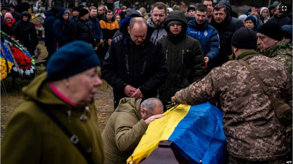 People attend a funeral ceremony for Ukrainian serviceman Yurii Kulyk, 27, killed in Donetsk region, in Kalynivka, near Kyiv, on February 21, 2023, amid the Russian invasion of Ukraine. (Photo by Dimitar DILKOFF / AFP)