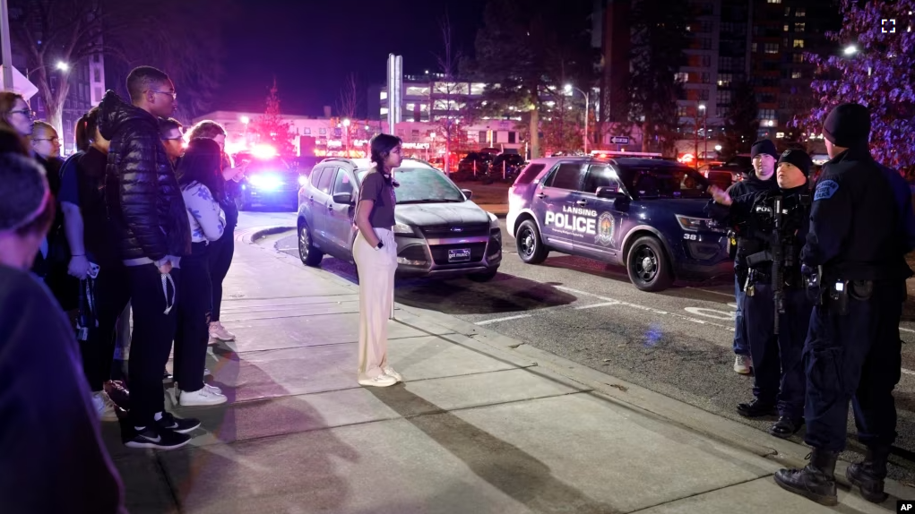 Students get directions from police on the campus of Michigan State University after a shelter in place order was lifted early Tuesday, Feb. 14, 2023, in East Lansing, Michigan. (AP Photo/Al Goldis)