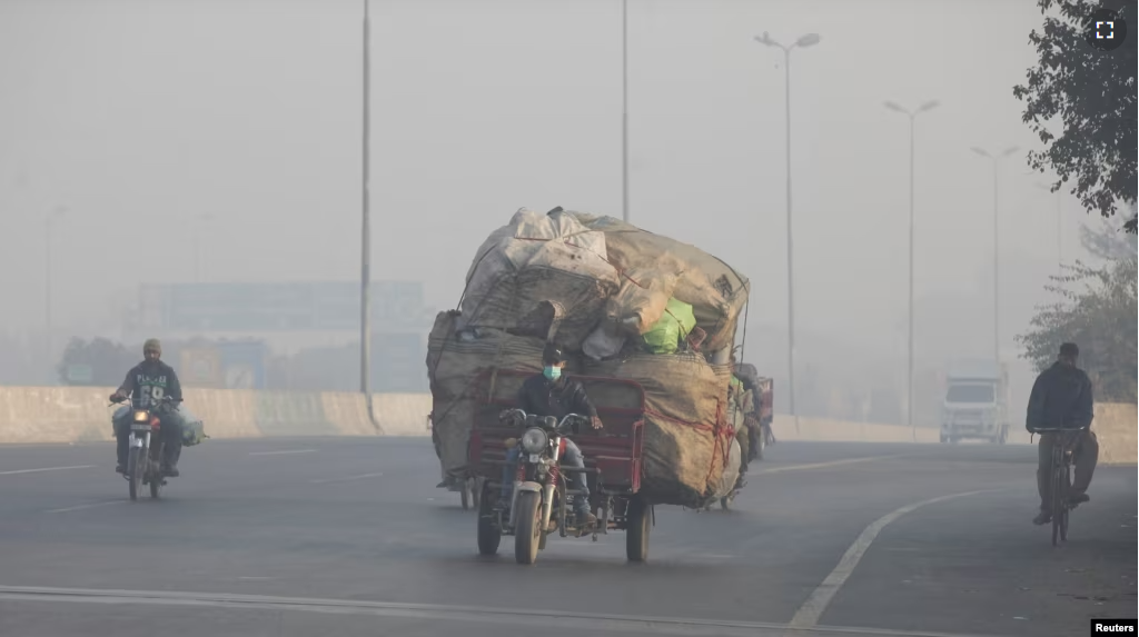 FILE - A man rides a motor tricycle, loaded with sacks of recyclables, amid dense smog in Lahore, Pakistan November 24, 2021. (REUTERS/Mohsin Raza/File Photo)