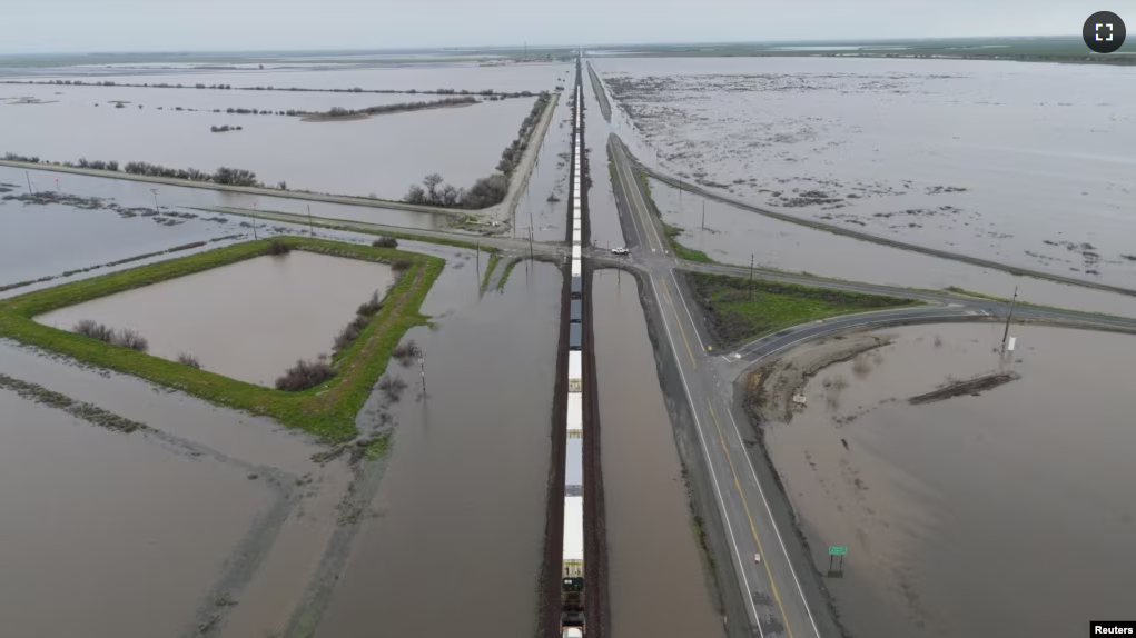 A train passes as floodwaters from the Tule River inundate the area after days of heavy rain in Corcoran, California, U.S. on March 22, 2023. (REUTERS/David Swanson)