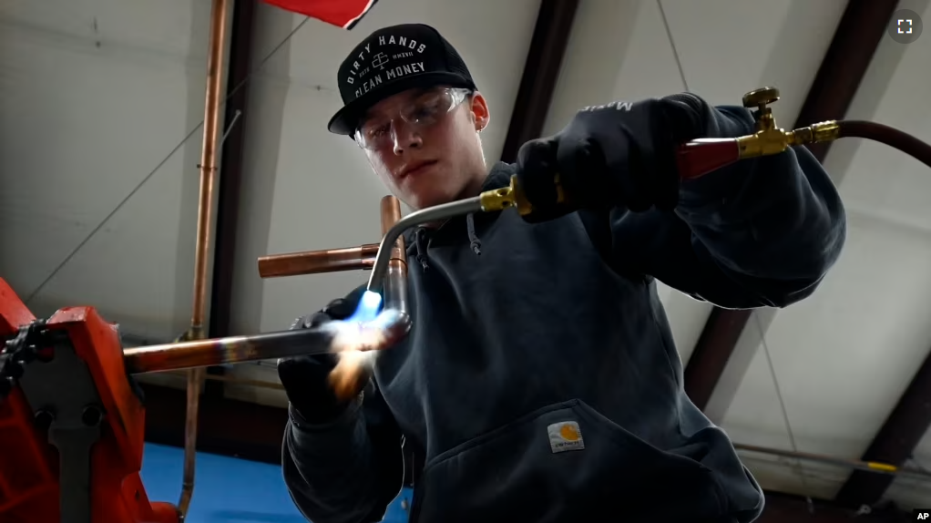 Boone Willams, 20, left, brazes a copper pipe during a second-year apprentice training program class at the Plumbers and Pipefitters Local Union 572 facility in Nashville, Tenn. (AP Photo/Mark Zaleski)