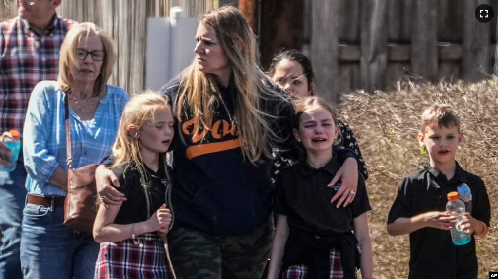 Children and a woman leave the reunification center at Woodmont Baptist Church after a shooting at a school on March 27, 2023, in Nashville, Tennessee. (AP Photo/John Bazemore)