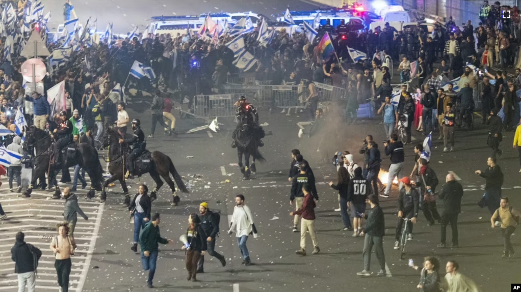 Israeli police disperse demonstrators blocking a highway during a protest against plans by Prime Minister Benjamin Netanyahu's government to overhaul the judicial system in Tel Aviv, Israel, Monday, March 27, 2023. (AP Photo/Oren Ziv)