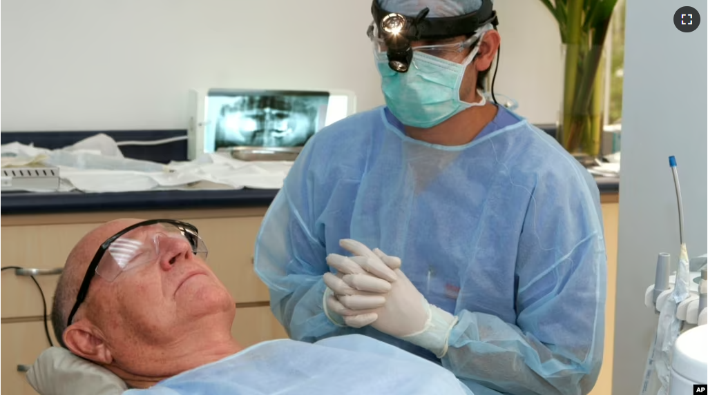 FILE - In this photo made June 26, 2009, Costa Rican Dr. Luis Obando, right, prepares to perform a root canal on Bill Jones, of Dallas, Texas at Meza Dental Care in San Jose, Costa Rica. (AP File photo)