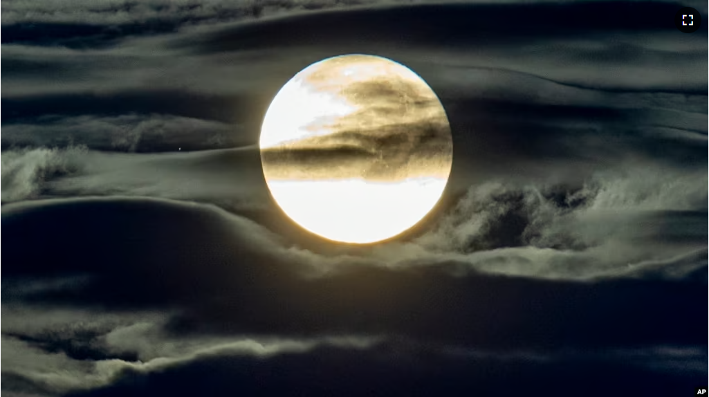 In this Sept. 2, 2020 file photo, the full moon shines surrounded by clouds in the outskirts of Frankfurt, Germany. (AP Photo/Michael Probst, File)