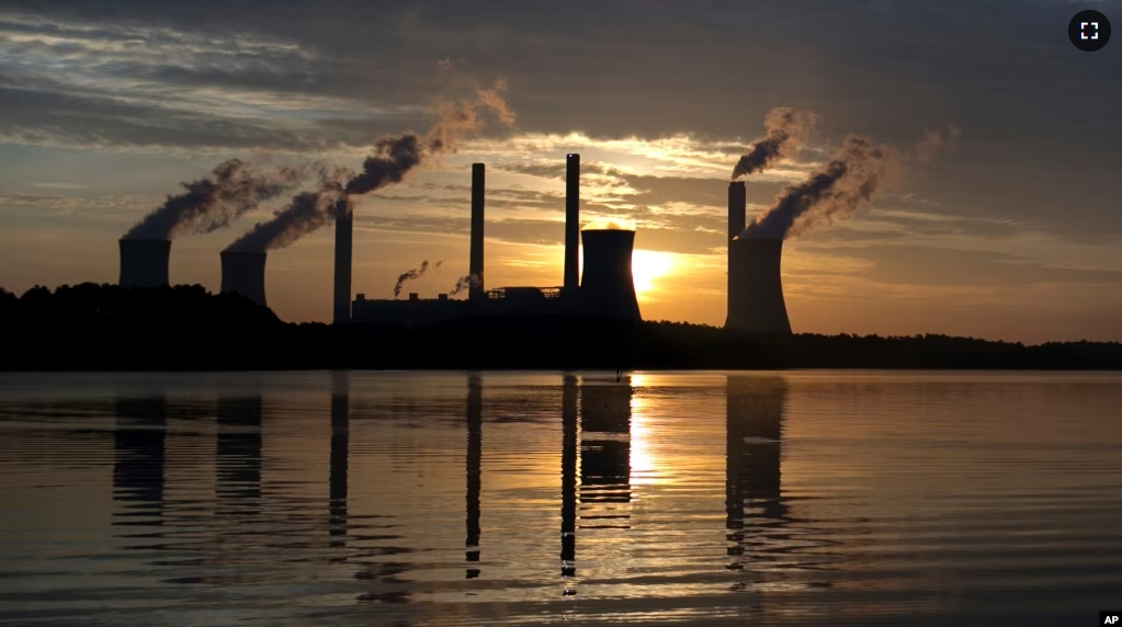 FILE - In this June, 3, 2017, file photo, the sun sets behind Georgia Power's coal-fired Plant Scherer, one of the nation's top carbon dioxide emitters, in Juliette, Ga. (AP Photo/Branden Camp, File)