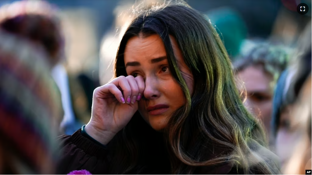 FILE - A mourner wipes a tear during a vigil honoring the students killed and injured in Monday's shootings at Michigan State University, at The Rock on the grounds of the university in East Lansing, Mich., Wednesday, Feb. 15, 2023. (AP Photo/Paul Sancya)