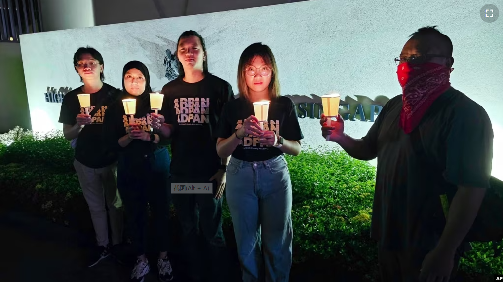 In this image taken and provided by Anti-Death Penalty Asia Network, members of Anti-Death Penalty Asia Network (ADPAN) hold candle outside Singapore Embassy in Kuala Lumpur, Malaysia Wednesday, April 26, 2023. (ADPAN via AP)