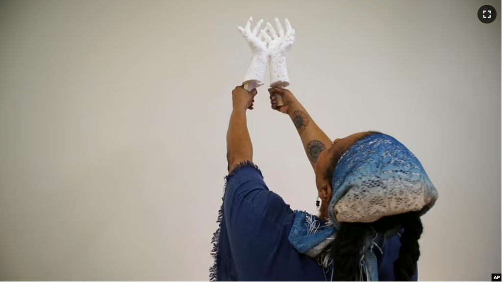 Crystal Kornickey holds up casts of her hands in a studio at the Gibbes Museum of Art in Charleston, S.C., on Thursday, Feb. 16, 2023. (AP Photo/Allen G. Breed)