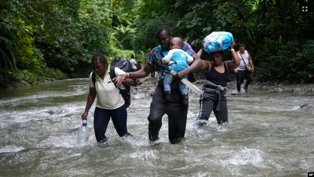 FILE - Haitian migrants wade through a river as they cross the Darien Gap, from Colombia into Panama, hoping to reach the U.S., Oct. 15, 2022. (AP Photo/Fernando Vergara, File)