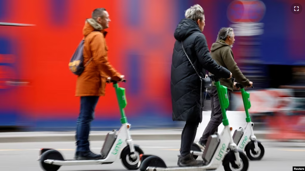 People ride electric scooters by Lime sharing service, on the eve of a public vote on whether or not to ban rental electric scooters, in Paris, France, April 1, 2023. (REUTERS/Sarah Meyssonnier)