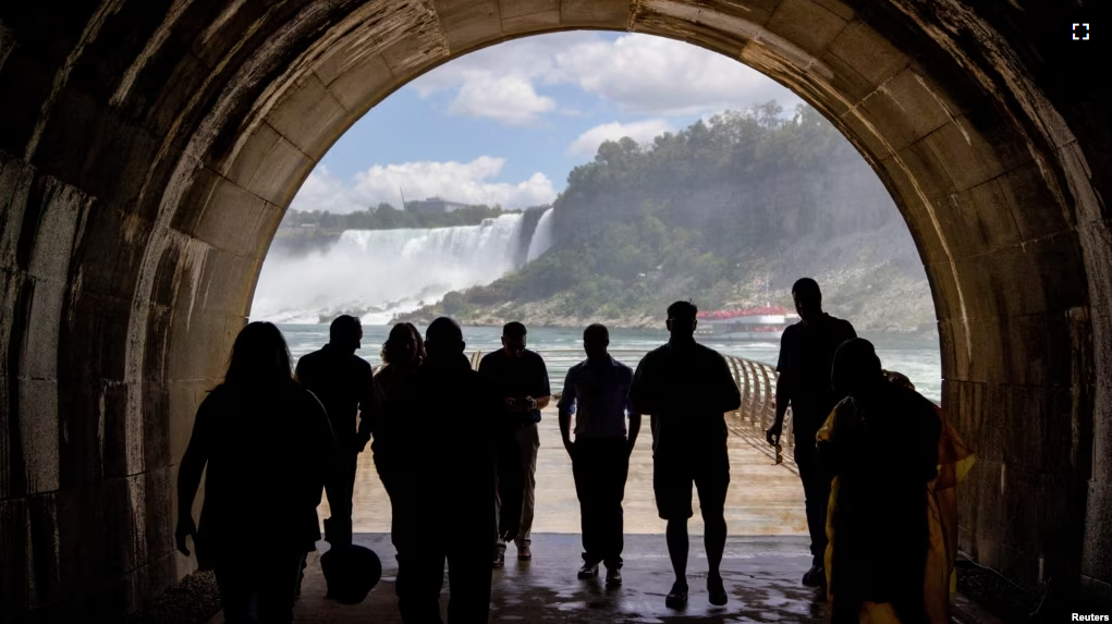 FILE - People walk through a tunnel, a new tourist attraction, at at the Niagara Parks Power Station in Niagara Falls, Ontario, Canada, June 28, 2022. (REUTERS/Carlos Osorio)