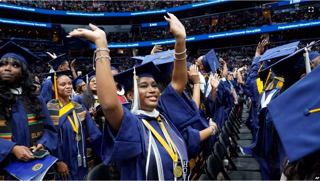 A graduate waves as students arrive Howard University's commencement in Washington, Saturday, May 13, 2023. (AP Photo/Alex Brandon)