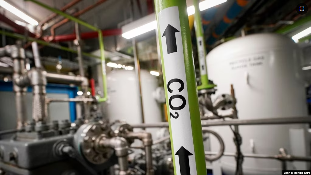 A liquid carbon dioxide pipe is labeled in a production room of The Grand Tier luxury apartment building, where the carbon byproduct of a natural gas fired water boiler is repurposed for industrial sale, Tuesday, April 18, 2023, in New York. (AP Photo/John Minchillo)