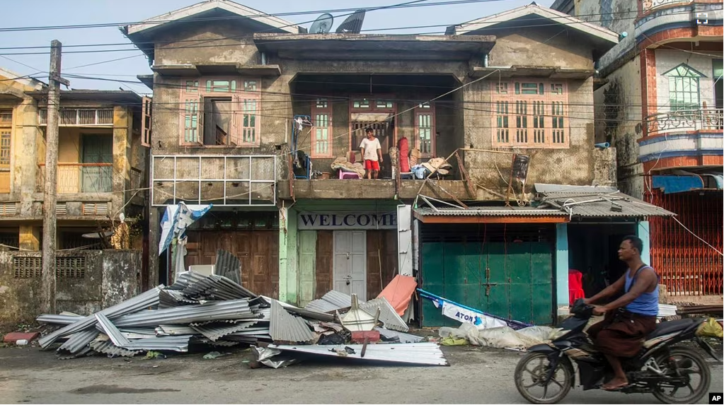 A local rides motorbike past damaged buildings after Cyclone Mocha in Sittwe township, Rakhine State, Myanmar, Monday, May 15, 2023. (AP Photo, File)